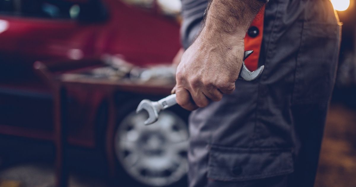 mechanic holding a wrench in an automotive repair shop