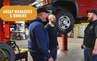 Shop owner, manager, and technician talking in a repair shop