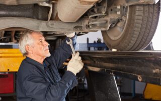 experienced mechanic working under a car